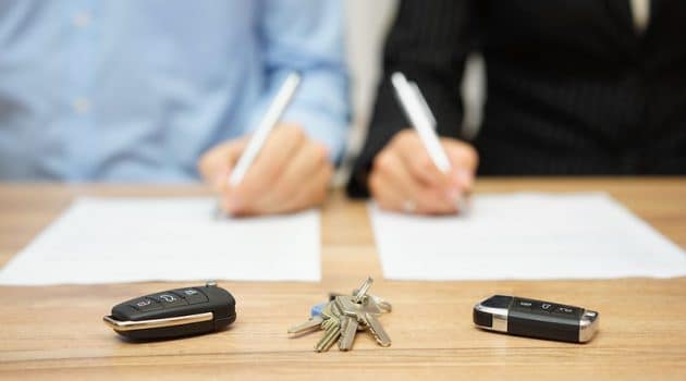 Desk with two hands signing a paper